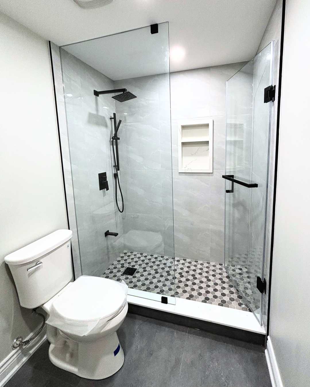 Grey vanity with white quartz counter, black shower faucet and