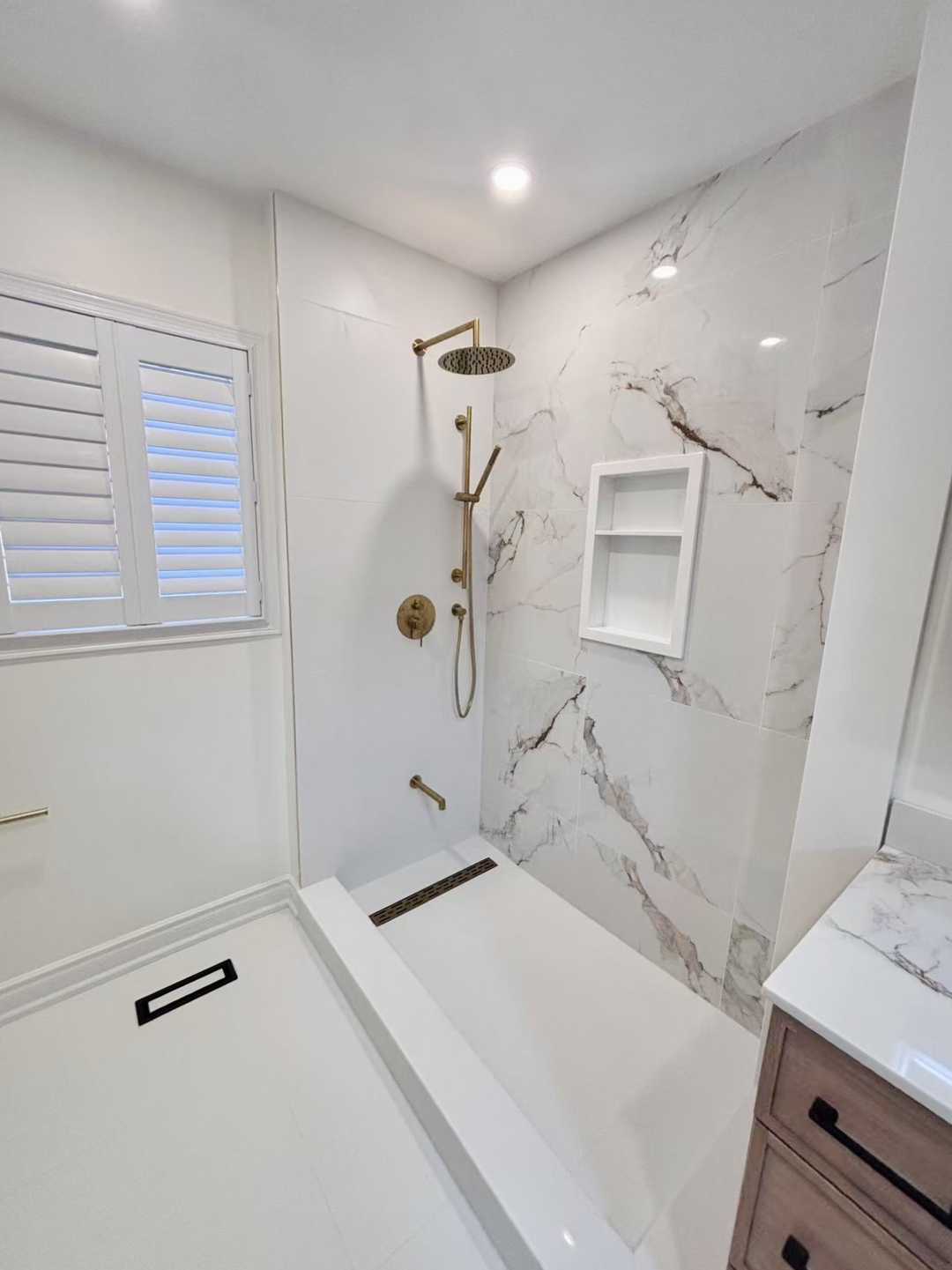 Black kodaen fixture with grey tone of tile and vanity,