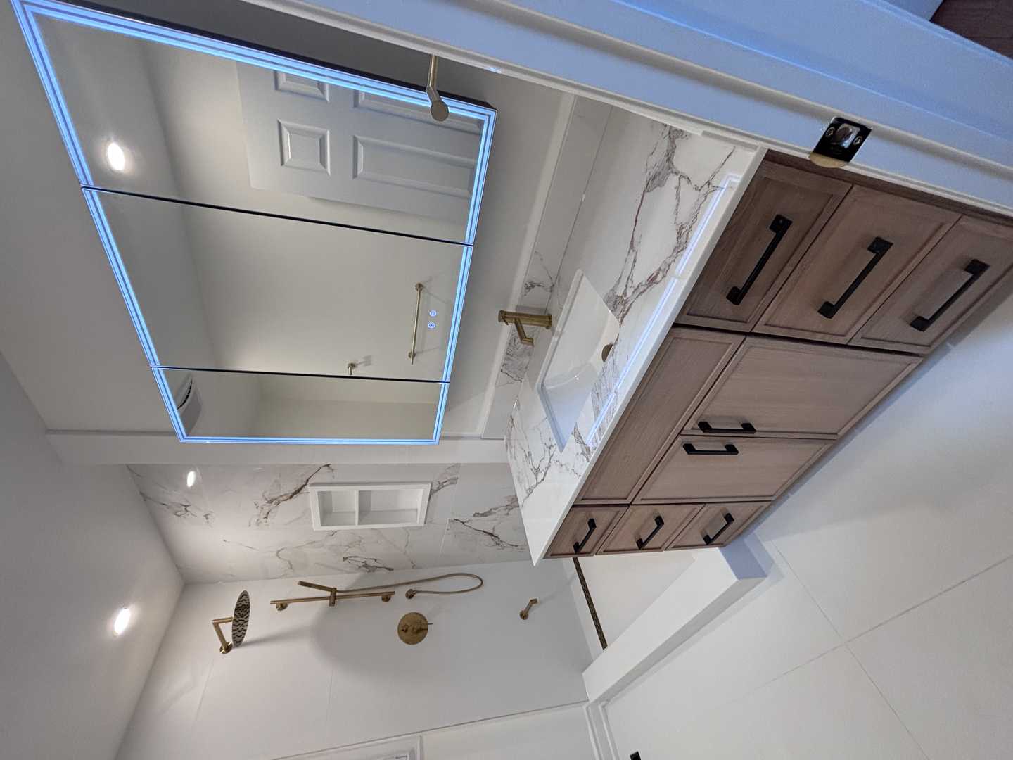 Black kodaen fixture with grey tone of tile and vanity,