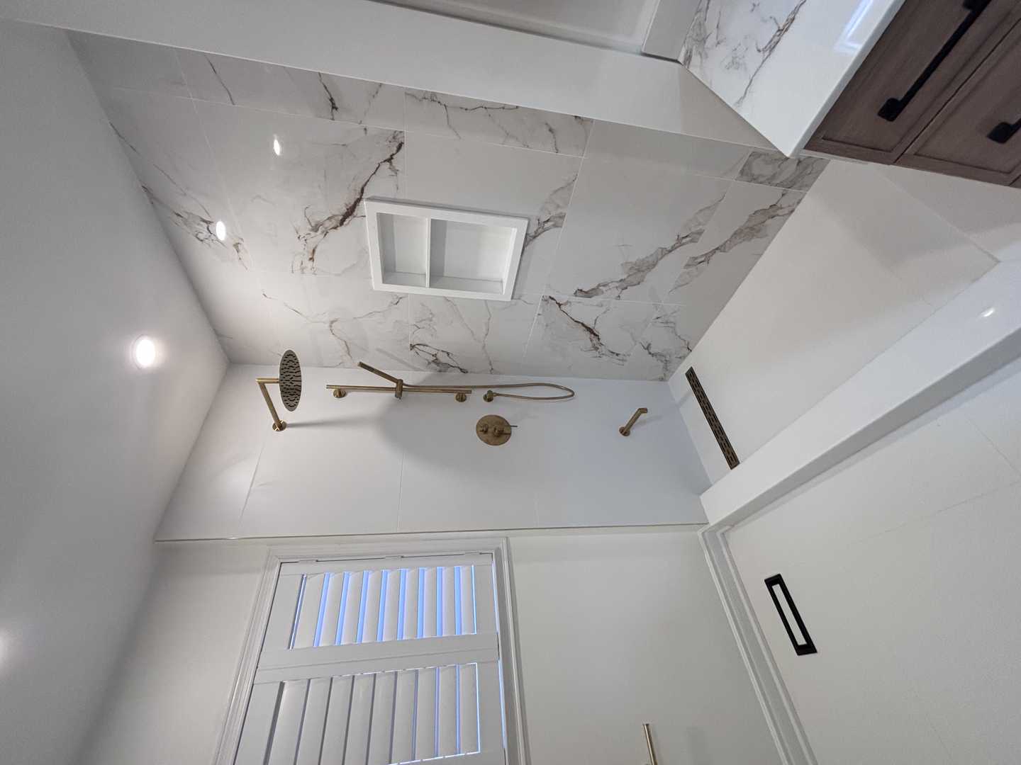 Black kodaen fixture with grey tone of tile and vanity,