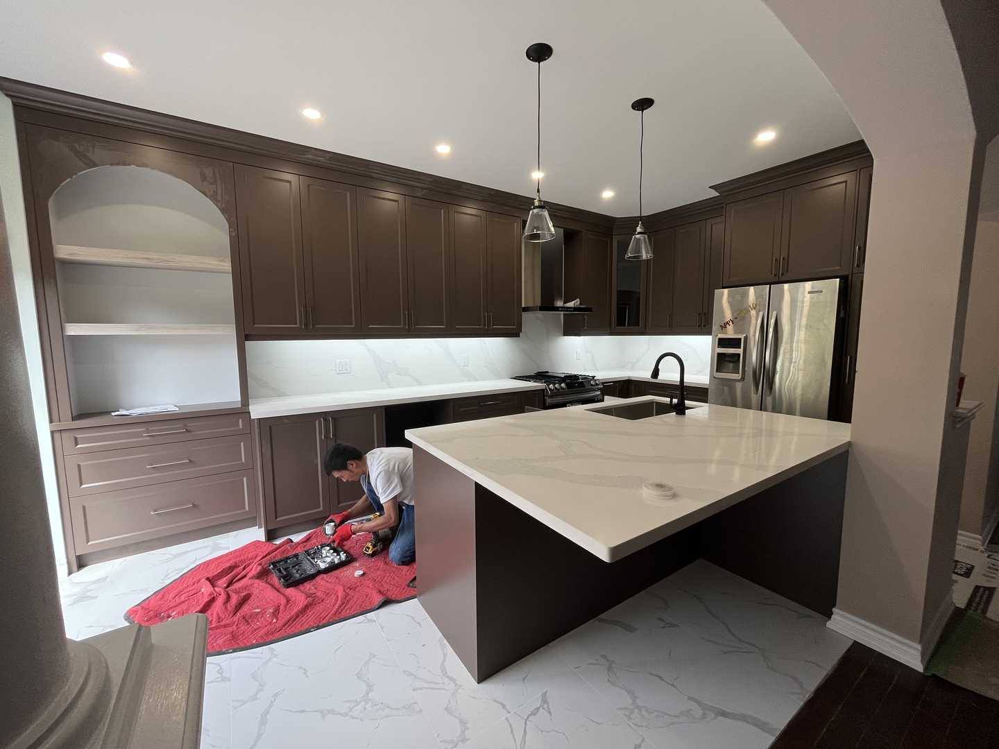 Dark Brown shaker kitchen cabinets with/ gold handle fixtures. arch